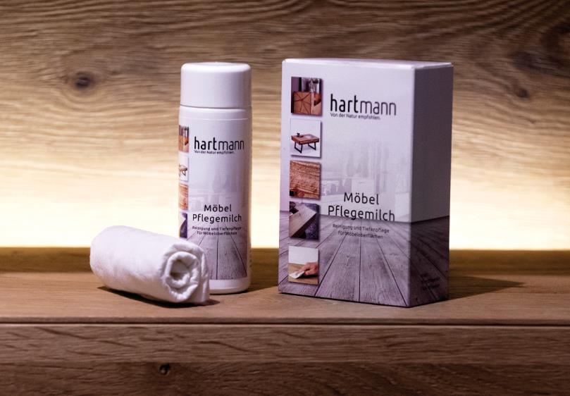 Hartmann Möbelpflegemilch Set mit Pflegeprodukt und Tuch auf Holzboden