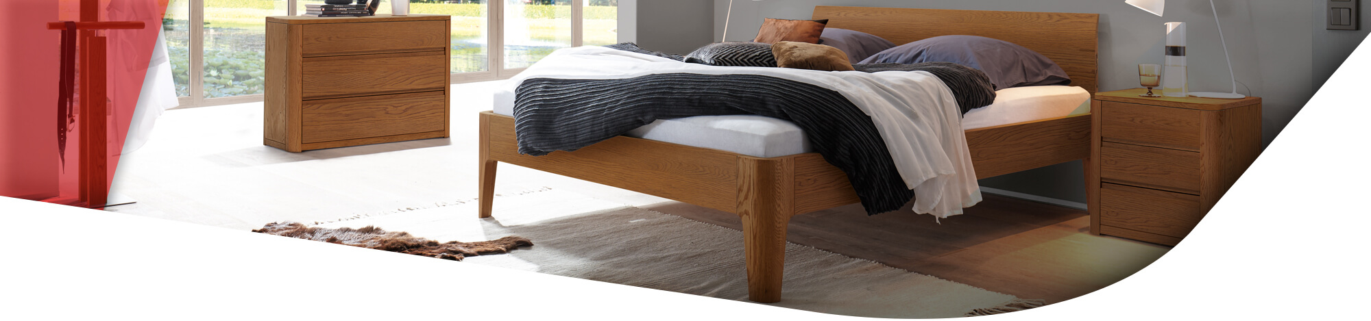 Schlafzimmer mit Holzmöbeln und hohem Bettgestell aus Holz
