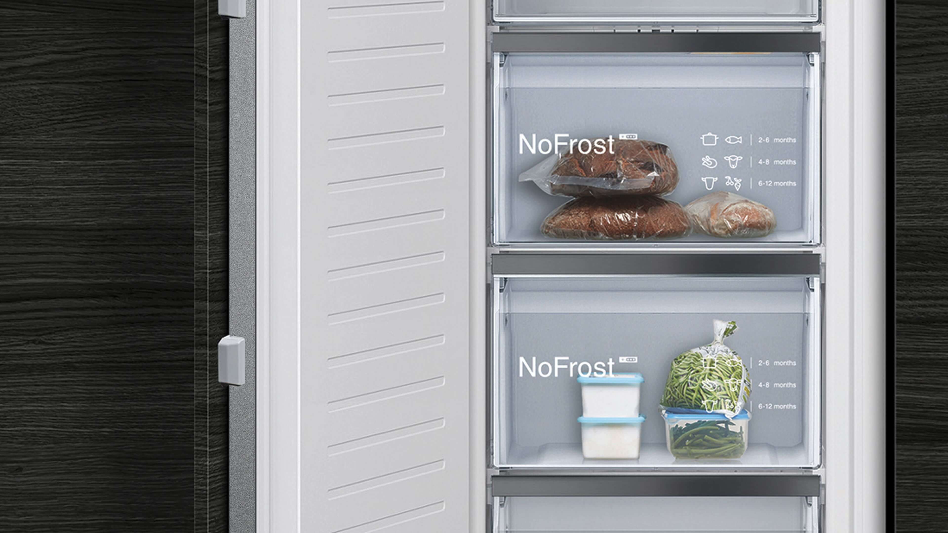ahaufnahme von zwei transparenten Gefrierfächern mit NoFrost-Aufschrift, gefüllt mit Brot und verpacktem Gemüse sowie Lagerzeitempfehlungen auf dem Glas.
