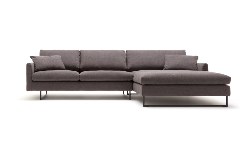 Modernes dunkelgraues Ecksofa mit Kissen und Metallfüßen auf weißem Hintergrund