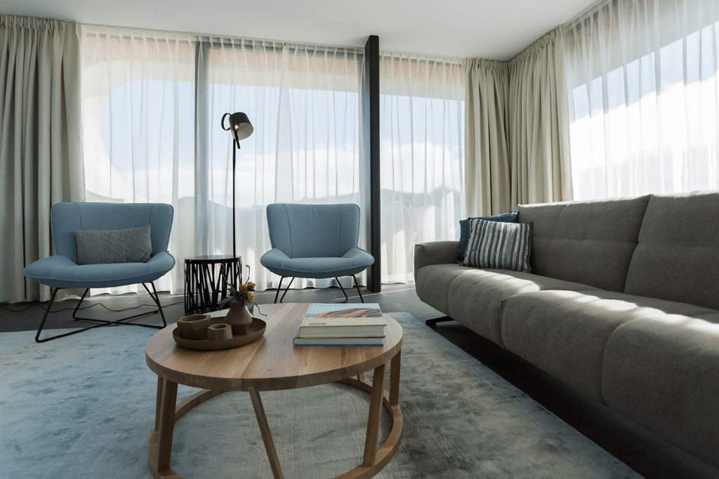 Wohnzimmer mit zwei hellblauen Sesseln und Holz Couchtisch