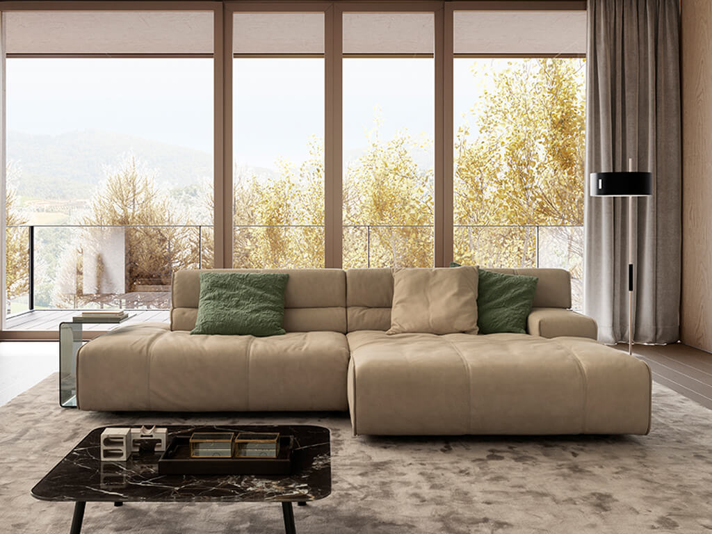 designwerk Colosseo - Polstergarnitur | B: 285 cm Gemütliches Wohnzimmer mit modernem beigem Sofa, grünen Kissen und großem Panoramafenster mit Blick auf die Natur