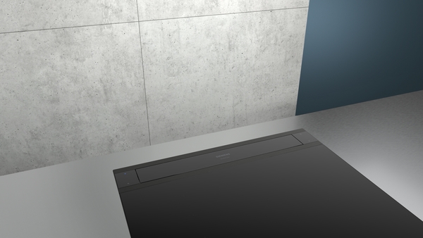 Teilansicht einer modernen Küche mit schwarzem Einbaugerät und Betonwand