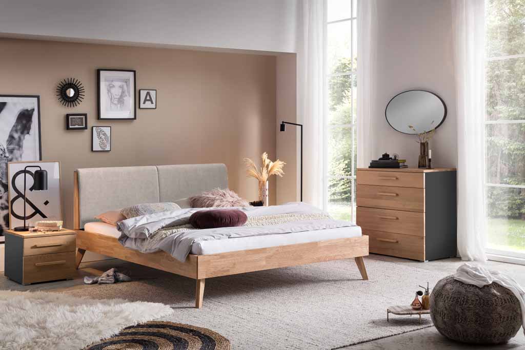 Gemütliches Schlafzimmer mit stilvollem Doppelbett aus Holz, dekorativen Wandbildern und einem großen Fenster mit Blick ins Freie