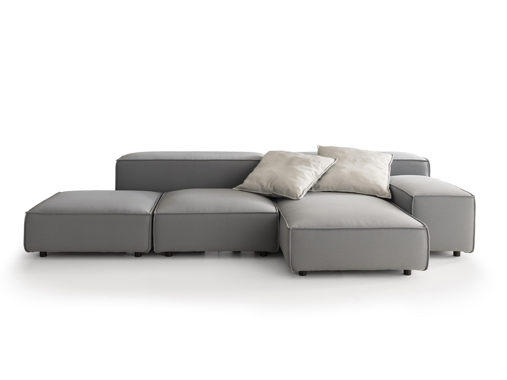 Ein modulares Outdoor-Sofa in Dunkelgrau, bestehend aus mehreren Elementen, die zu einer L-förmigen Sitzlandschaft angeordnet sind. Zwei hellbeige Kissen liegen auf den Rückenelementen. Der Hintergrund ist weiß.
