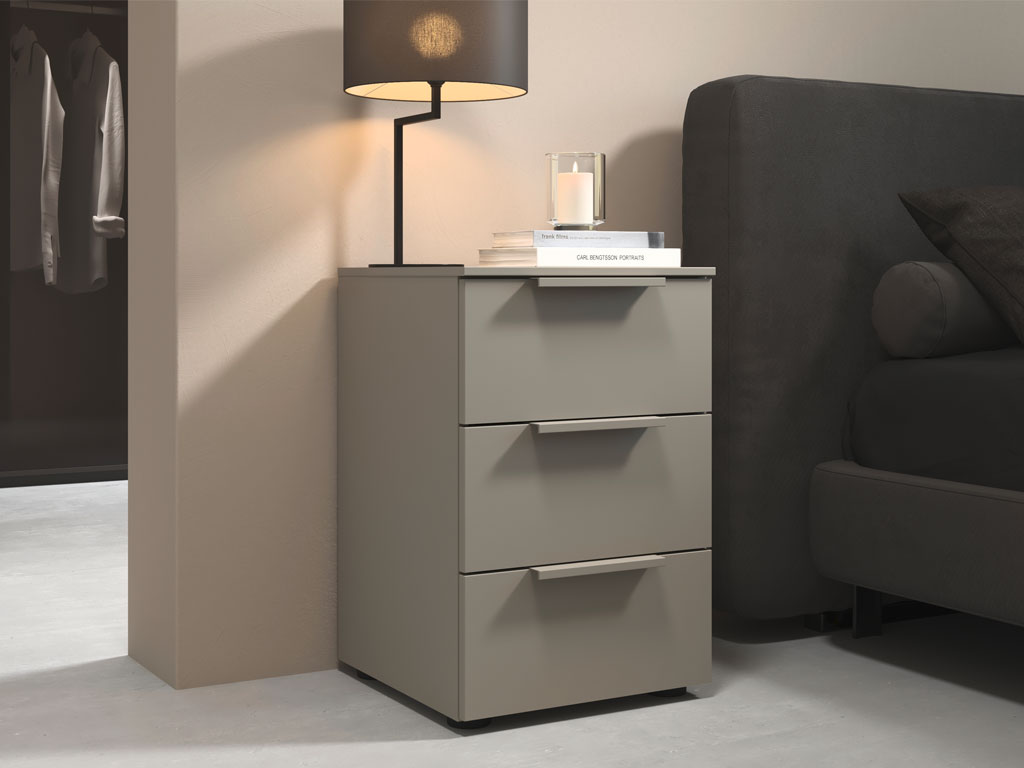 grauer nachttisch mit drei schubkästen platziert neben einem bett in einem modernen zimmer stilvoll dekoriert