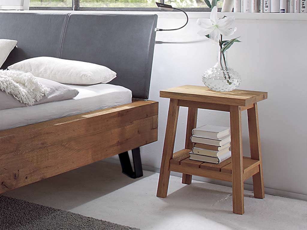 brauner Holzhocker auf vier beinen mit Ablage unten und Griffauffräsung oben auf der Platte stilvoll dekoriert in einem freundlichen zimmer ludo von hasena