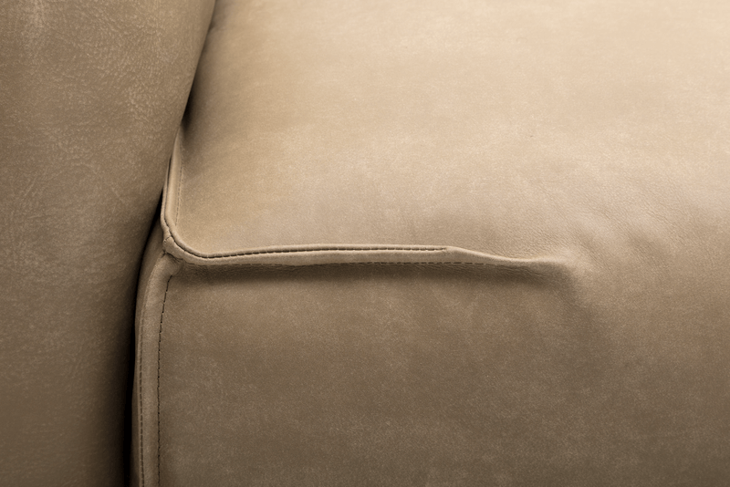 Detailansicht eines beigen Ledersofas mit sorgfältig genähten Kanten