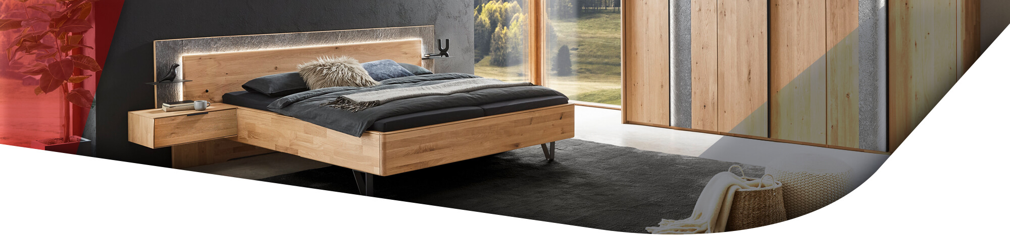 Schlafzimmer mit Bett und großem Kleiderschrank mit Stein Akzent und aus Massivholz