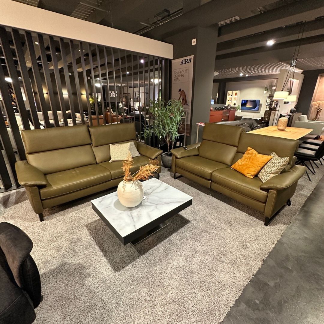 Polsteria TREVI | Polstergarnitur | 2-Sitzer mittel + 2-Sitzer klein Elegantes Wohnzimmer mit grünen Ledersofas und einem modernen Marmortisch auf grauem Teppich