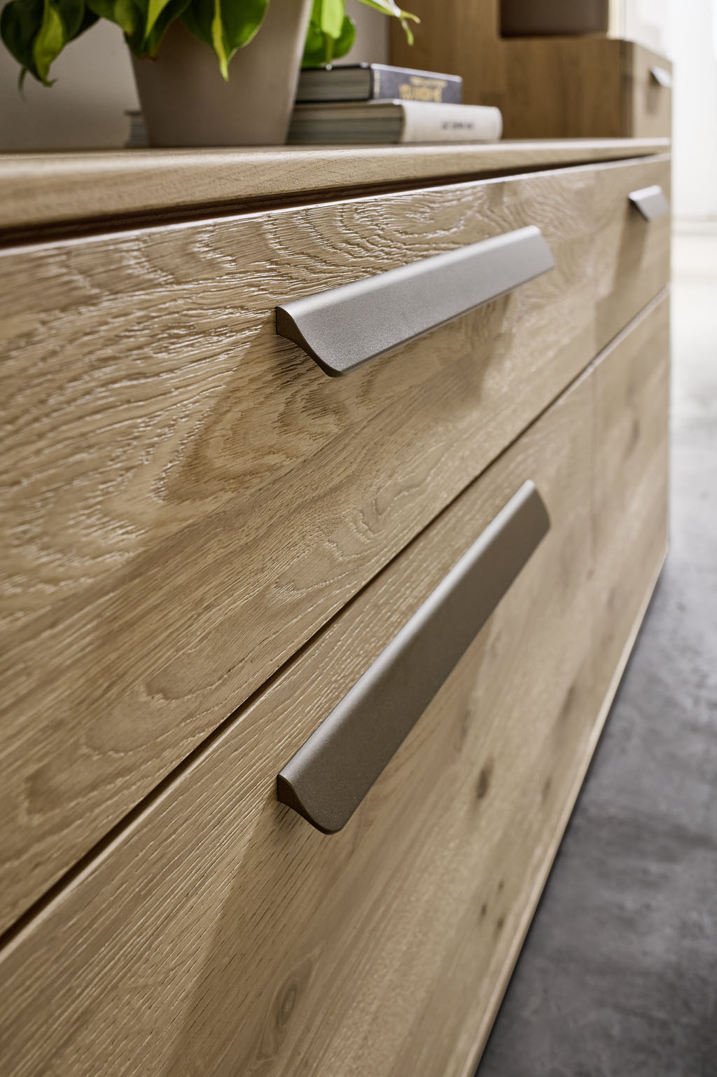 Detailaufnahme eines braunen Schrankes mit zwei Schubladen und silberfarbigen Griffen