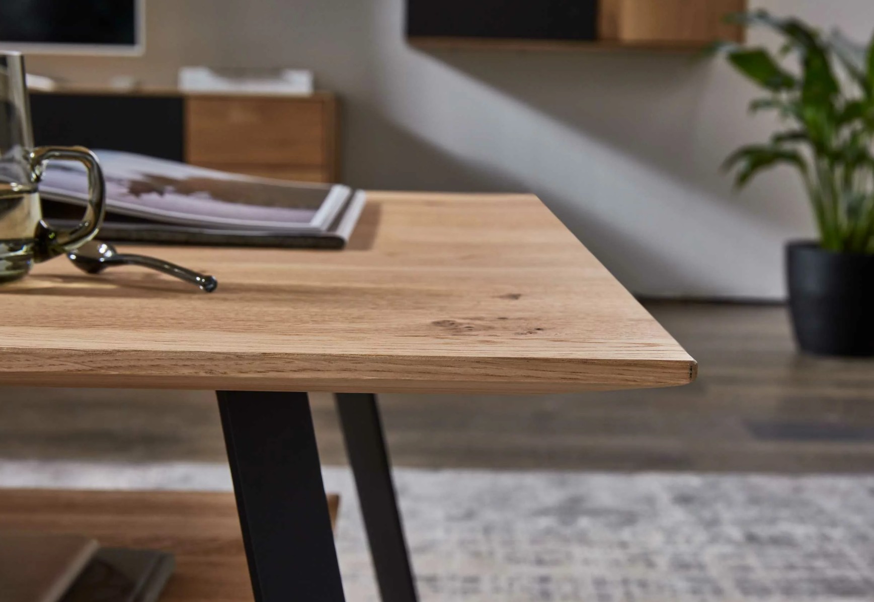 Detailaufnahme eines Holztisches mit schwarzem Gestell stilvoll dekoriert