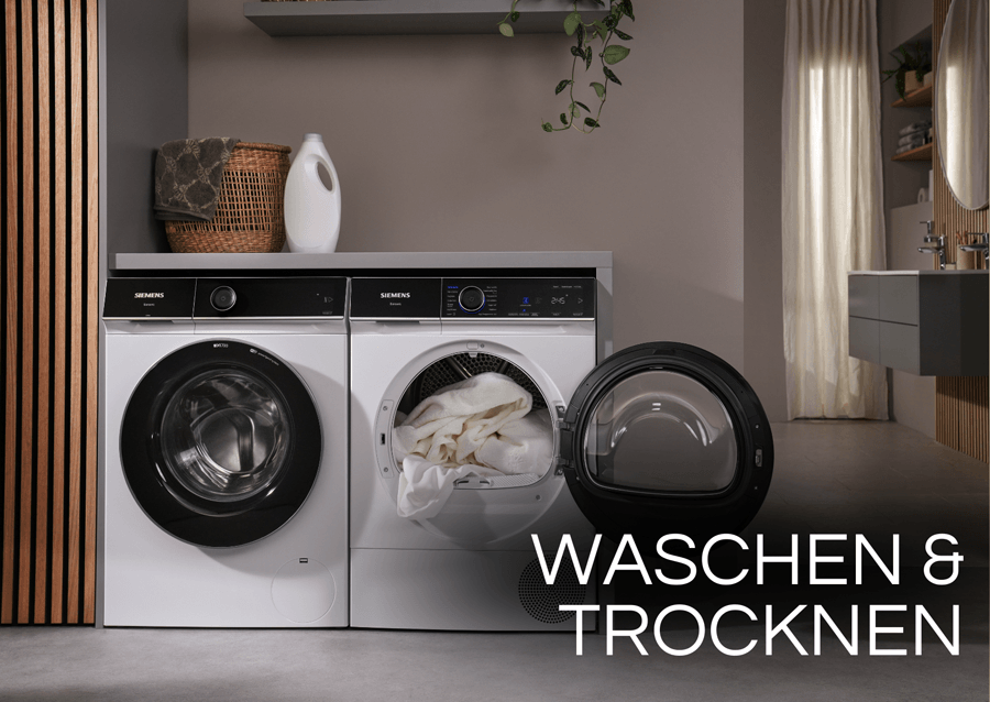Moderne Siemens Waschmaschine und ein geöffneter Wäschetrockner mit weißer Wäsche in einem stilvollen Badezimmer.