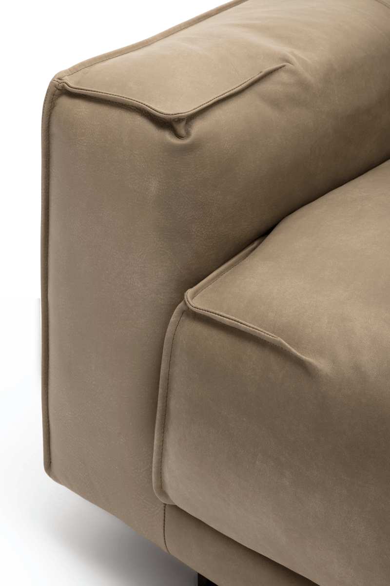 Nahaufnahme des Polsterstils eines beigen Sofas, die Kissen und Nähten zeigt