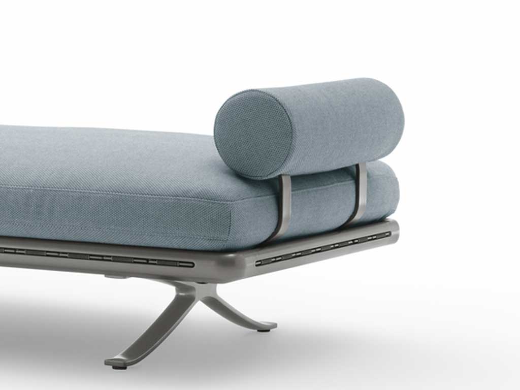 Rolf Benz Yoko 219 - Seitenteil- und Rückenbügel Nahaufnahme eines modernen grauen Daybeds mit einem geschwungenen Stahlfuß und einem zylinderförmigen Nackenkissen.