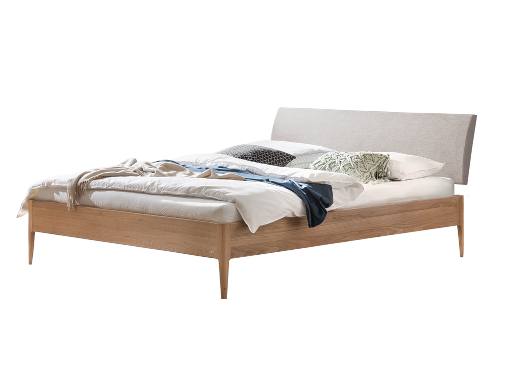  Ein fertig montiertes Hasena Fanano Bett mit einem Bettrahmen aus hellem Eichenholz und einem hellgrauen, gepolsterten Kopfteil. Das Bett ist gemacht mit weißen Laken, einer Decke und Kissen. Der Hintergrund ist weiß.