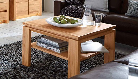 Wöstmann Soleo 3000 - Couchtisch/Beistelltisch | Type 9511/9521 | B: 70,0 cm | konfigurierbar Ein stilvoller Couchtisch aus Holz mit Büchern, einem Teller mit Früchten und einem Glas im gemütlichen Wohnzimmer.