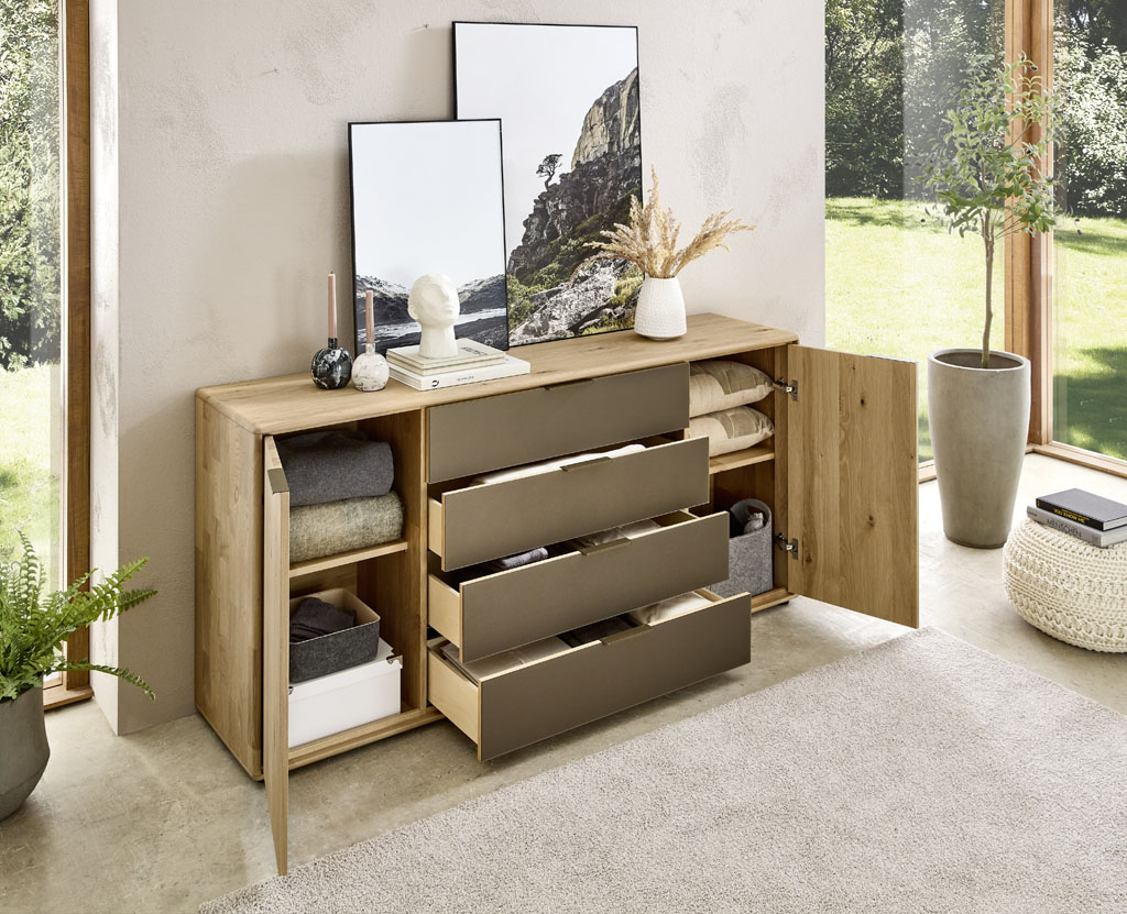 Moderne braune Kommode mit zwei Türen und vier Schubladen stilvoll dekoriert in einem modernen Zimmer