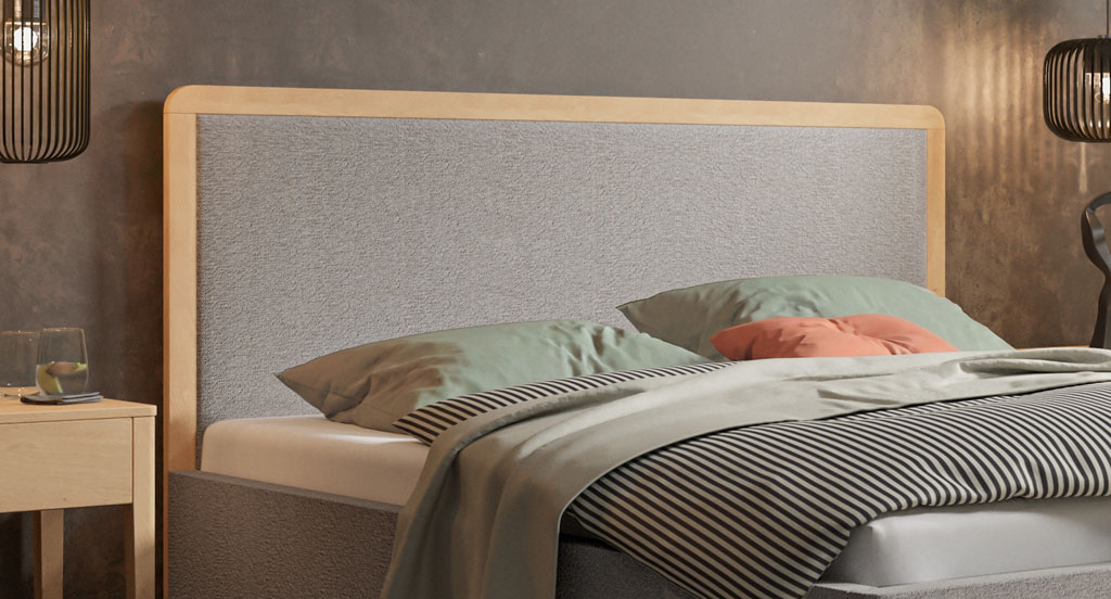 Nahaufnahme des hellgrau bezogenen Polsterkopfteils mit massiver Holzeinfassung aus heller, geölter Eiche in einem Schlafzimmer (KI-generiert)