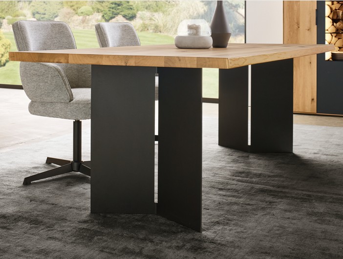 Nahaufnahme eines Holzesstisches mit Metallwangen in schwarz