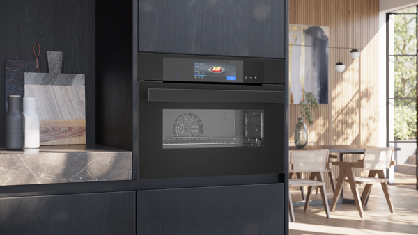 Ein eingebauter, schwarzer Siemens studioLine Kompaktbackofen mit großem TFT-Full-Touchdisplay in einer dunklen Design-Küche.