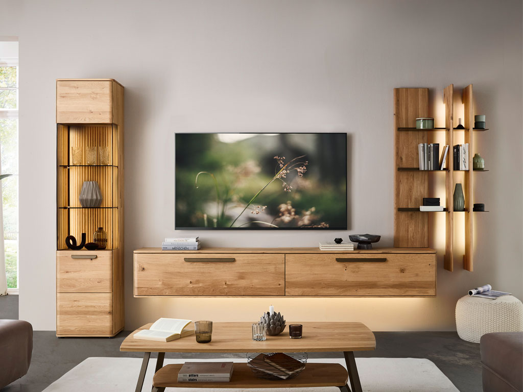 moderne Wohnwand aus Eiche mit einem Hängelowboard, beleuchtetem Regal und beleuchteter Vitrine stilvoll dekoriert in einem modernem Zimmer