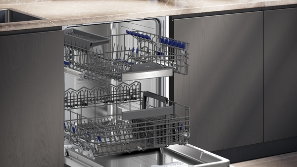 Offene Geschirrspülmaschine mit herausgezogenen Körben in einer Küchenzeile