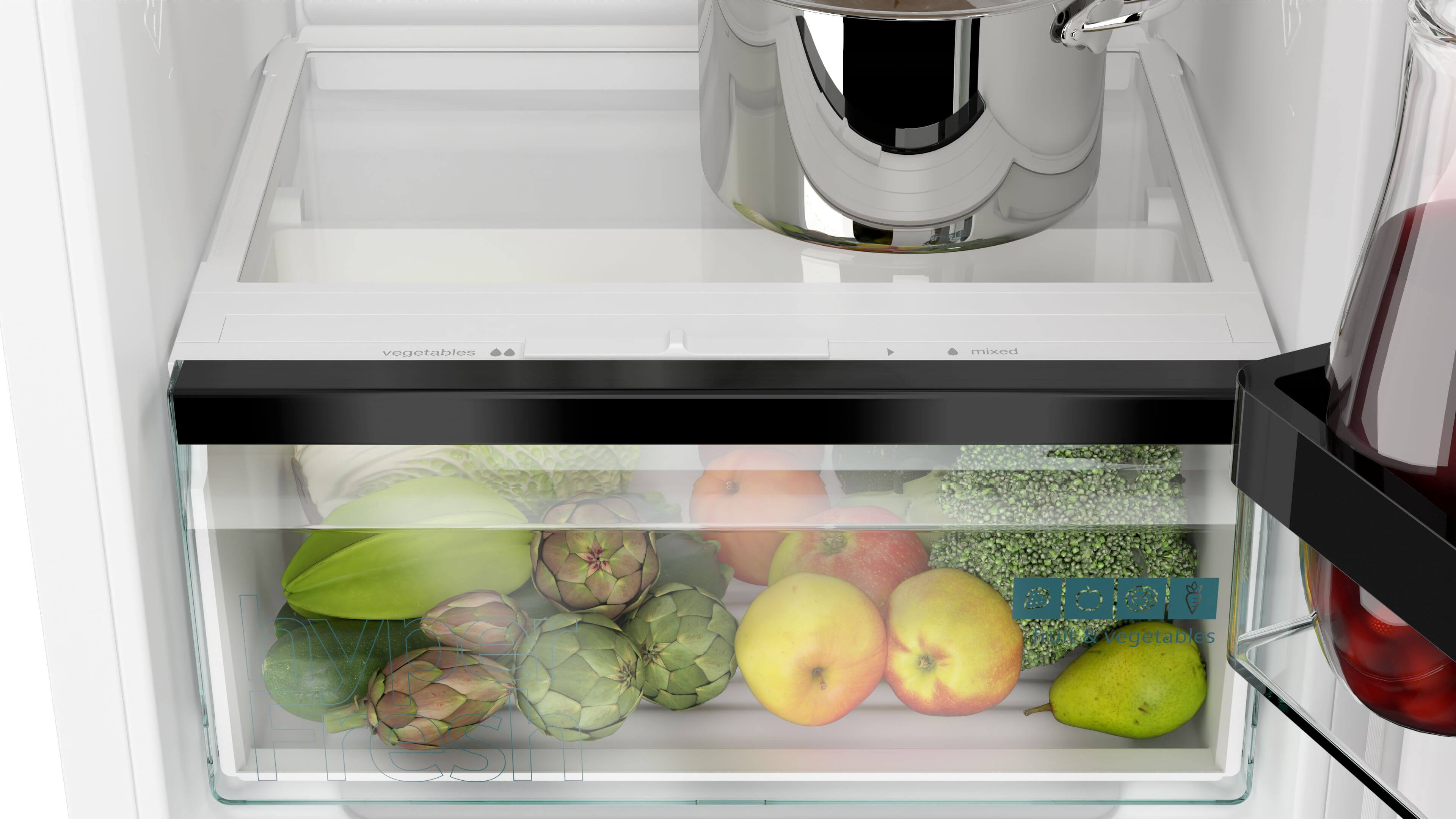 Offener Kühlschrank mit frischem Gemüse und Obst in der Schublade sowie einem Topf auf dem Regal.