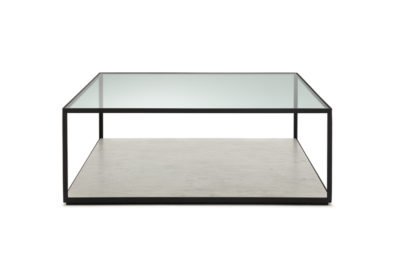 Moderner quadratischer Couchtisch mit transparenter Glasplatte und robustem schwarzem Metallrahmen, darunter eine Ablagefläche.