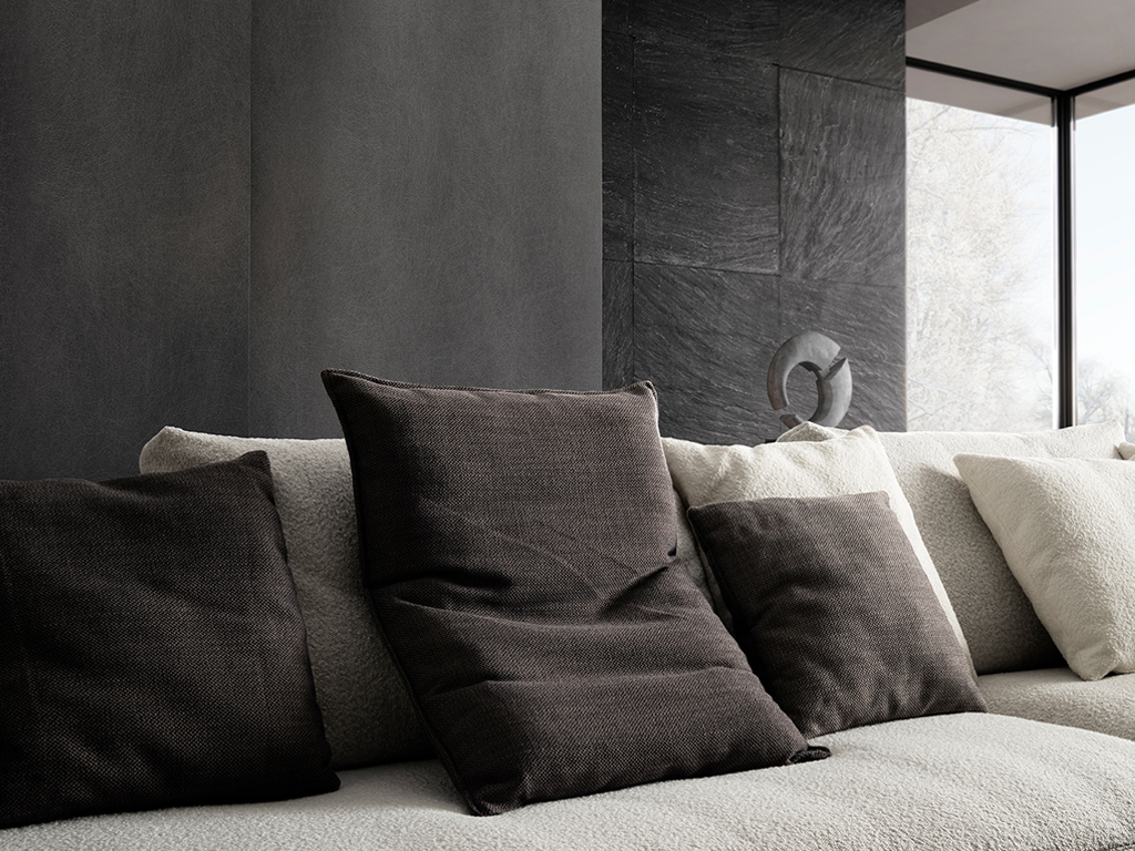 Nahaufnahme eines hellen Sofas mit verschiedenen Kissen in beige und braun Tönen
