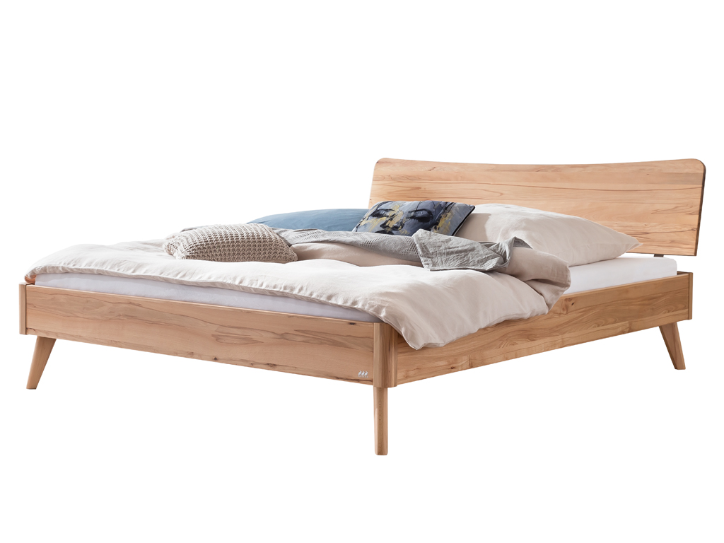 Ein freigestelltes Hasena Bett Caluso aus Wildbuche. Das Bett hat ein geschwungenes Kopfteil, schräg ausgestellte Beine und ist mit Kissen und einer Decke dekoriert.