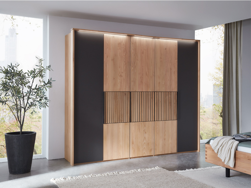Moderner Kleiderschrank aus Holz mit dunklen Akzenten und Schiebtüren in einem stilvollen Schlafzimmer
