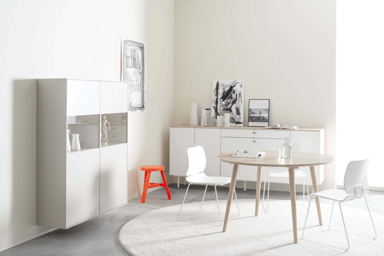 Esszimmer mit rundem Esstisch und weißen Beimöbeln