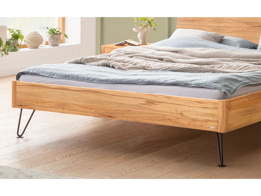Nahaufnahme des unteren Teils eines Hasena Bett Locarno mit einem Rahmen aus Wildbuche und schwarzen, anthrazitfarbenen Haarnadel-Beinen, in einem Schlafzimmer.