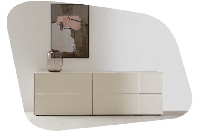 Minimalistisches Sideboard in Beige mit 6 Rastern. Auf dem Sideboard steht eine dekorative Vase sowie ein dezent auffälliges Bild.