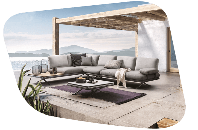 Gartenlounge mit hellgrauem Polster und seitlicher Ablage mit Holz