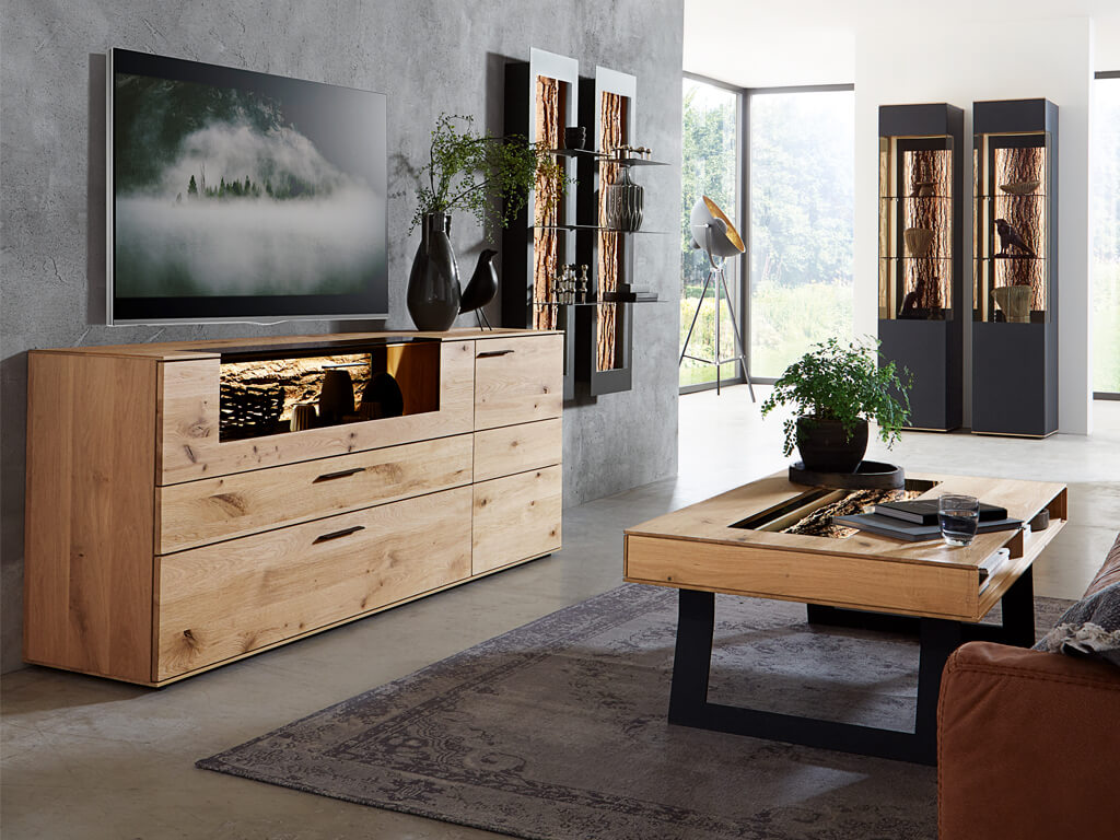 Massivholz Möbel im Wohnzimmer mit Lowboard und Couchtisch mit Vitrinenglas und Baumrinde im Hintergrund