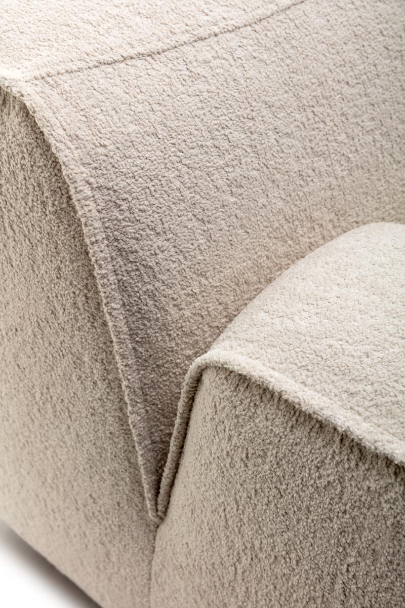 Detailaufnahme eines beigen Sofas vor weißem Hintergrund