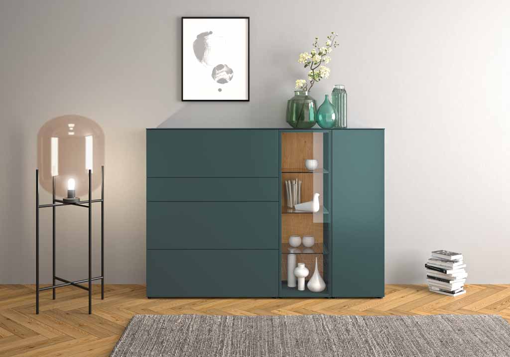 Sudbrock Cubo - Highboard mit Vitrinenausschnitt | B: 180 cm | Eiche canyon furniert, Lack blaugrün, Klarglas Schrank mit Glaselementen, dekoriert mit Vasen, Blumen und Skulpturen in einem stilvollen Wohnzimmer