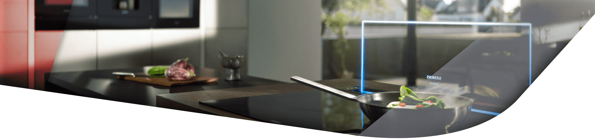 Ein modernes Kochfeld mit einer Pfanne darauf, daneben frisches Gemüse auf einem Schneidebrett in einer stilvollen Küche.