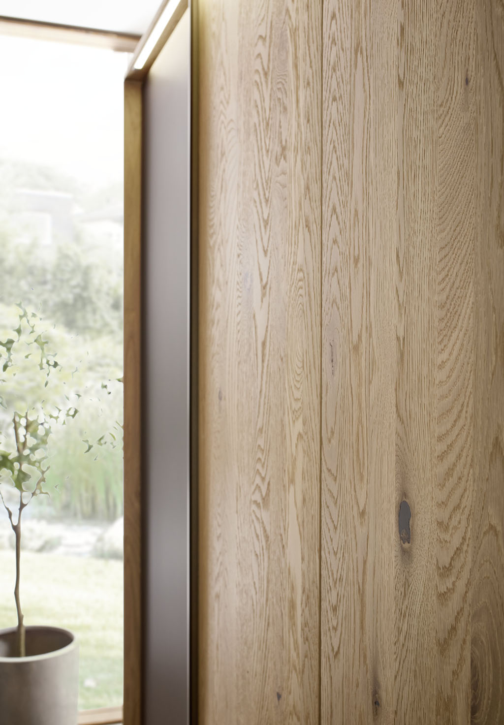 Detailaufnahme eines braunen Holz Kleiderschrankes mit Außentüren in mattem braun und Beleuchtung im Passepartout