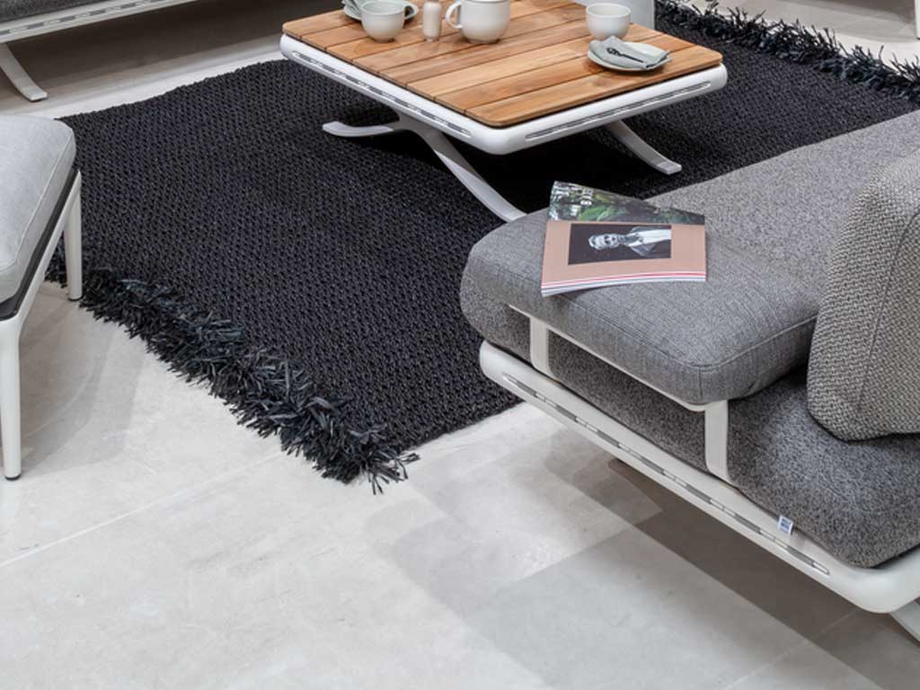 Rolf Benz Yoko 219 - Seitenteil- und Rückenbügel Ein elegantes Wohnzimmer mit dunkelgrauem Teppich, Holztisch und grauem Lounge-Sofa