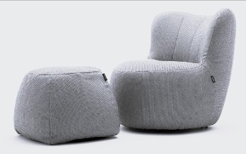 Designersessel-Set mit Poufhocker in schwarzweis vor hellem hintergrund