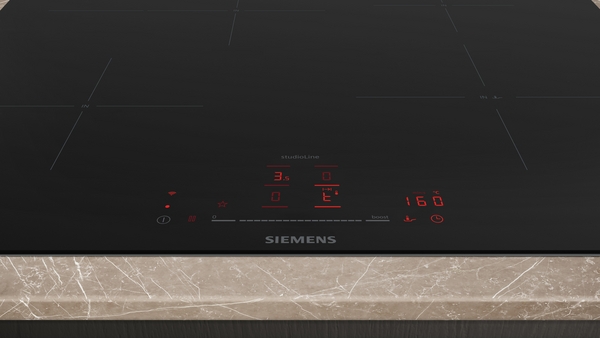 Nahaufnahme einer Siemens Induktionskochplatte mit digitalem Display und Touch-Bedienfeld auf einer Arbeitsplatte aus Marmor.