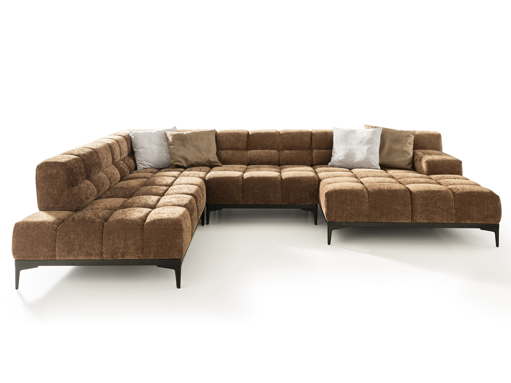 Ein großes, modulares Ecksofa in U-Form, bezogen mit einem braunen, texturierten Stoff mit gestepptem Muster. Das Sofa steht auf eleganten schwarzen Metallfüßen und ist mit vier Zierkissen in Hellgrau und Beige ausgestattet. Der Hintergrund ist weiß.