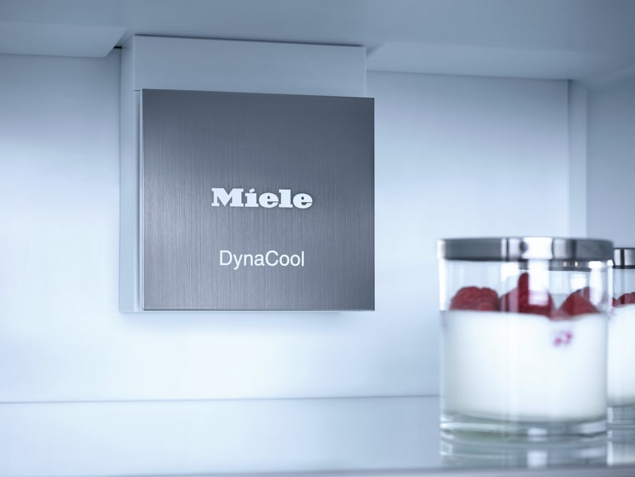Detaillierte Ansicht des Miele DynaCool-Elements im Inneren eines Kühlschranks. Im Vordergrund stehen Gläser mit Joghurt und Himbeeren, die die Frischefunktion symbolisieren.