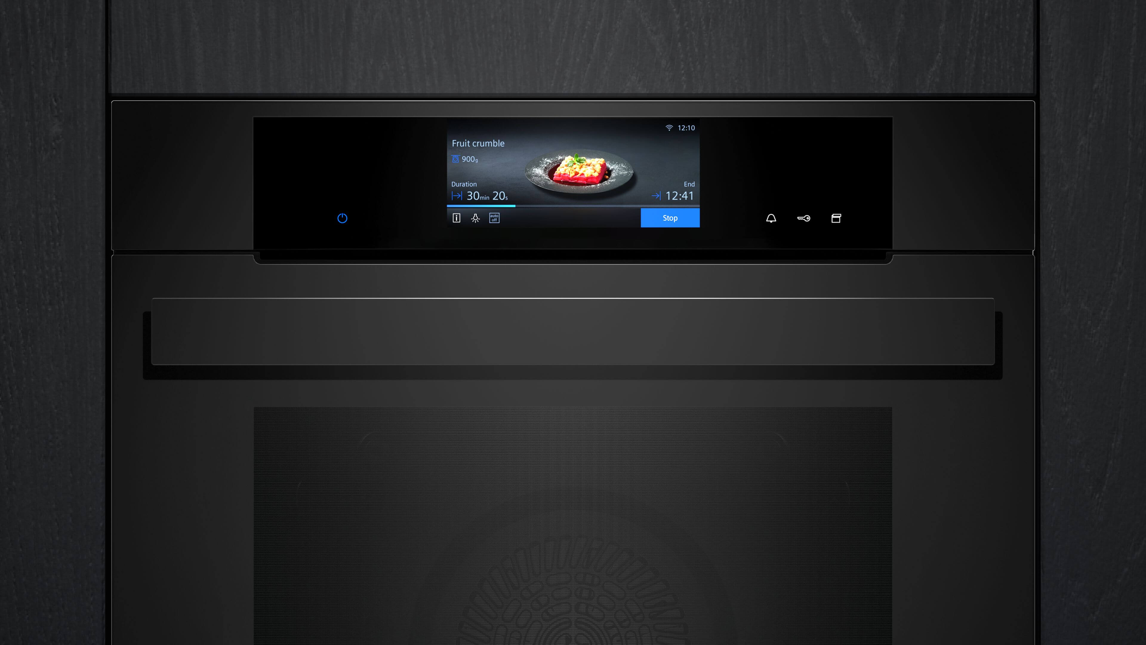 Nahaufnahme des digitalen Displays eines schwarzen Siemens Einbaubackofens, das den Fortschritt eines „Fruit crumble“ anzeigt.