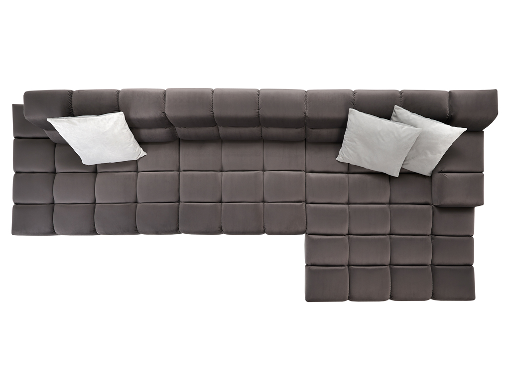 Eine Draufsicht auf ein langes L-förmiges Sofa in einem dunklen Taupe-Ton mit gesteppter Sitzfläche und Rückenlehne. Drei helle, graue Zierkissen sind auf der Rückenlehne platziert. Der Hintergrund ist weiß.