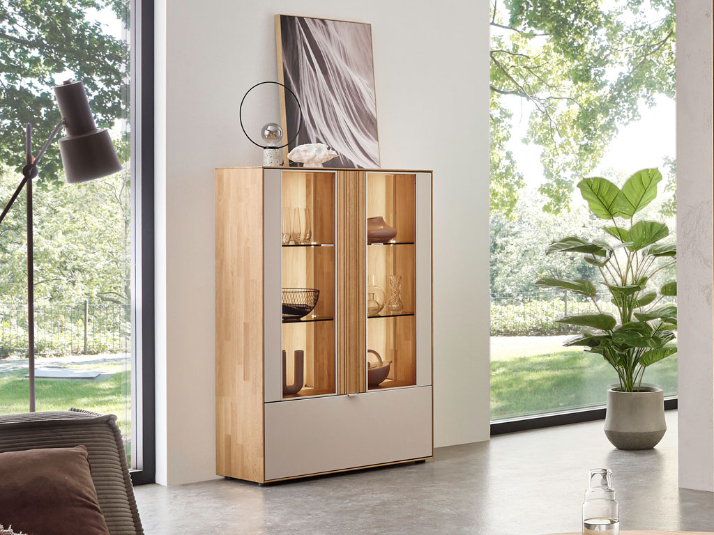 modernes Highboard mit Vitrinenausschnitt und Beleuchtung in braun-weiß stilvoll dekoriert in einem hellen Raum