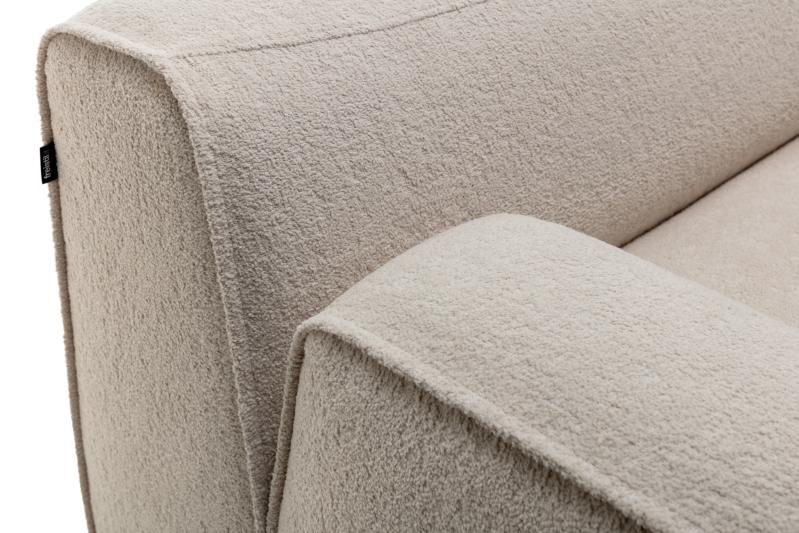 Detailaufnahme eines beigen Sofas vor weißem Hintergrund